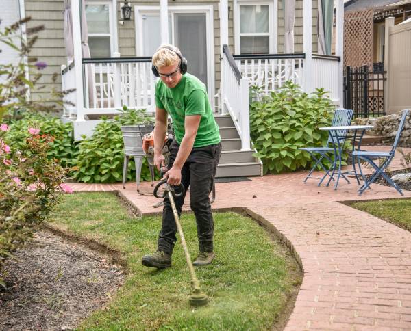 Man with a green t shirt cleaning his lawn—looking after a large garden