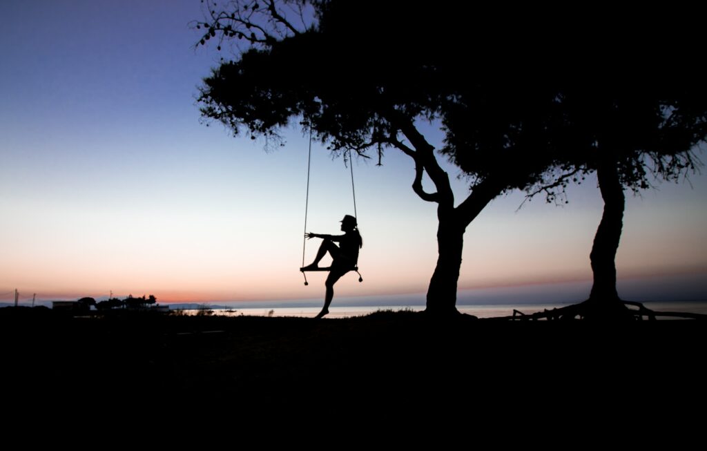 A girl sitting on a tree swing—how to hang a tree swing on an angled branch?