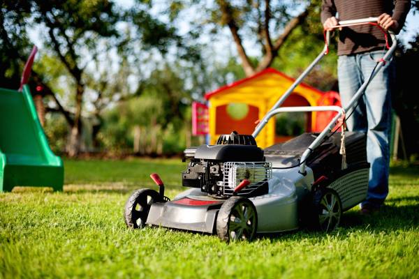 A man with a lawn mower—when can I mow after overseeding