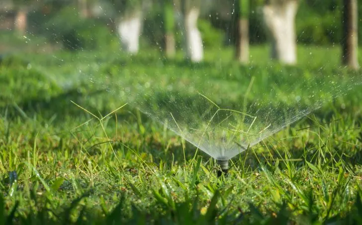 A water sprinkler system sprinkling water onto the lawn.