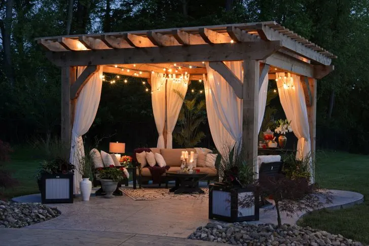 Photo of gazebo with curtain and string lights photo