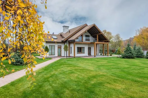 Yellow patches in a lawn of a cottage house How Often to Water Lawn in Summer