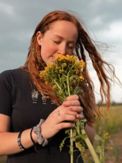 A woman holding a bunch of early sunflowers in her hands What Do Sunflowers Smell Like
