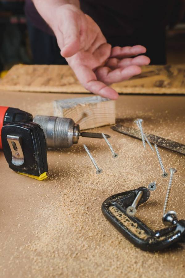 Carpenter throws screws on a workbench—how to make wood glue dry faster
