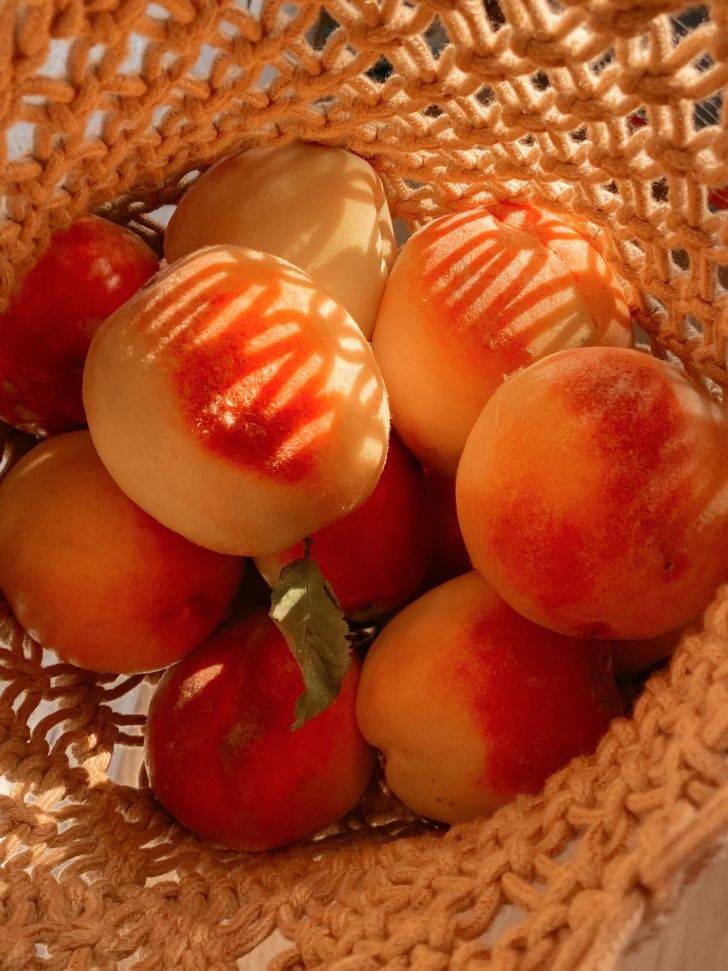 Fresh peaches in a brown woven basket