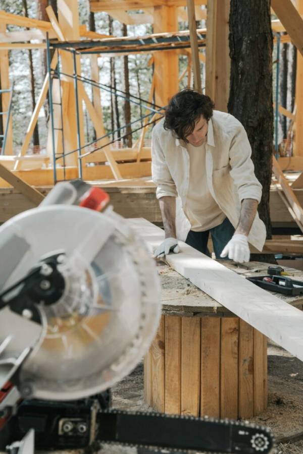 Person marking a wood piece—how to cut a 22.5 degree angle on a miter saw